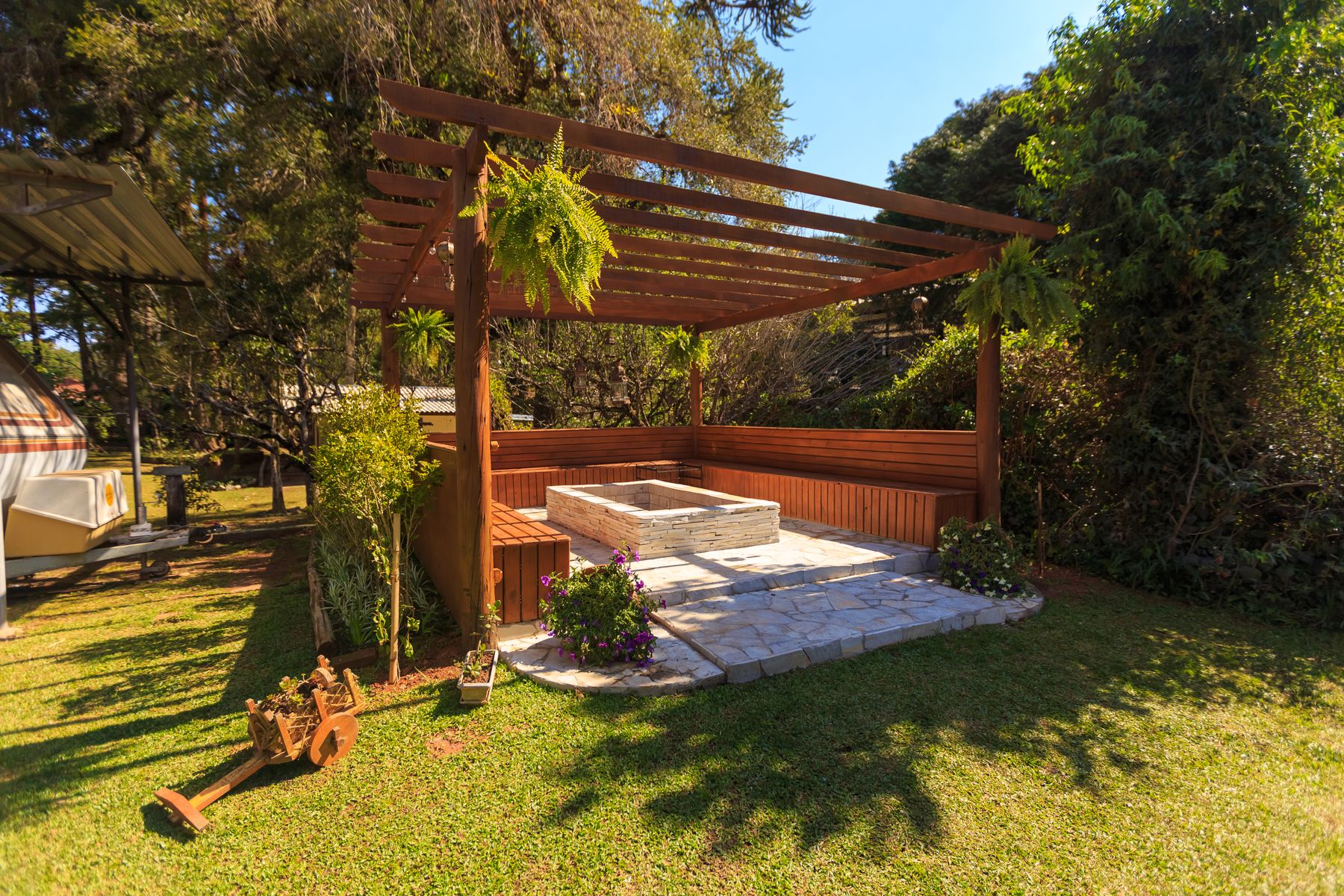 Wooden pergola with stone patio and fire pit
